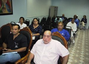 Personas sentadas escuchando atentos en la reunión